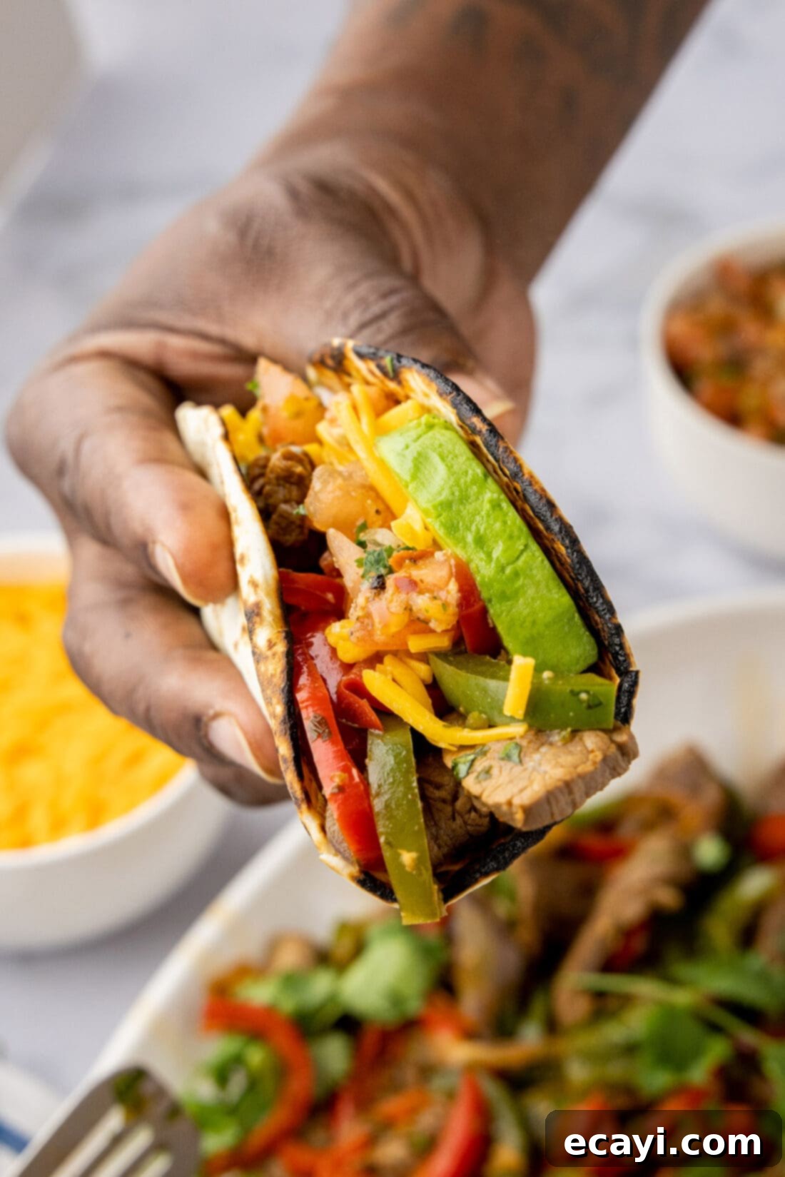 Sizzling Steak Fajitas 2 Hand holding Steak Fajitas wrapped in a tortilla