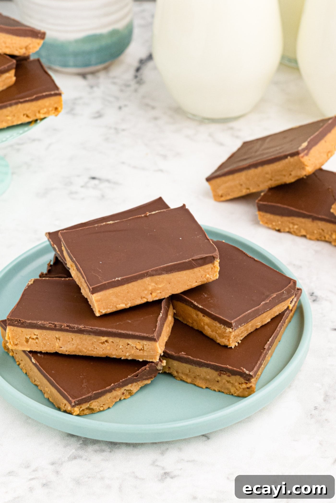 Peanut Butter Dream Bars 2 peanut butter bars stacked on a plate, showcasing the chocolate topping and dense base