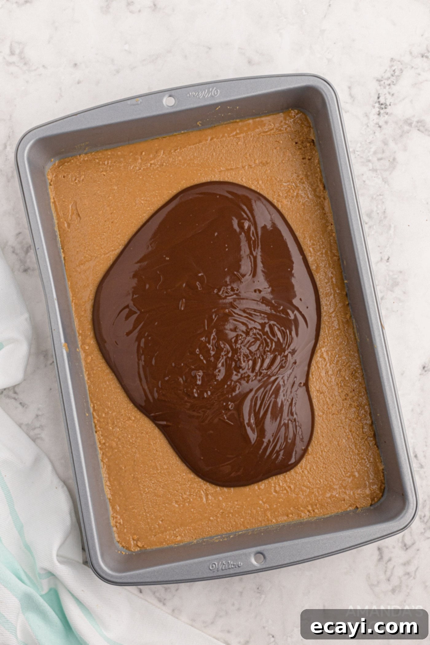 Peanut Butter Dream Bars 6 melted chocolate spread over the peanut butter bar base in a pan