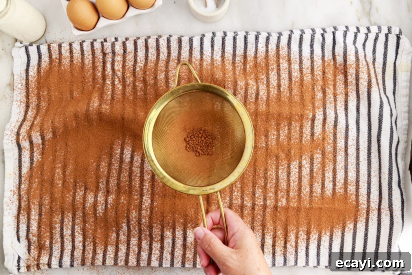 Velvet Chocolate Swirl 14 sifting cocoa powder over a tea towel