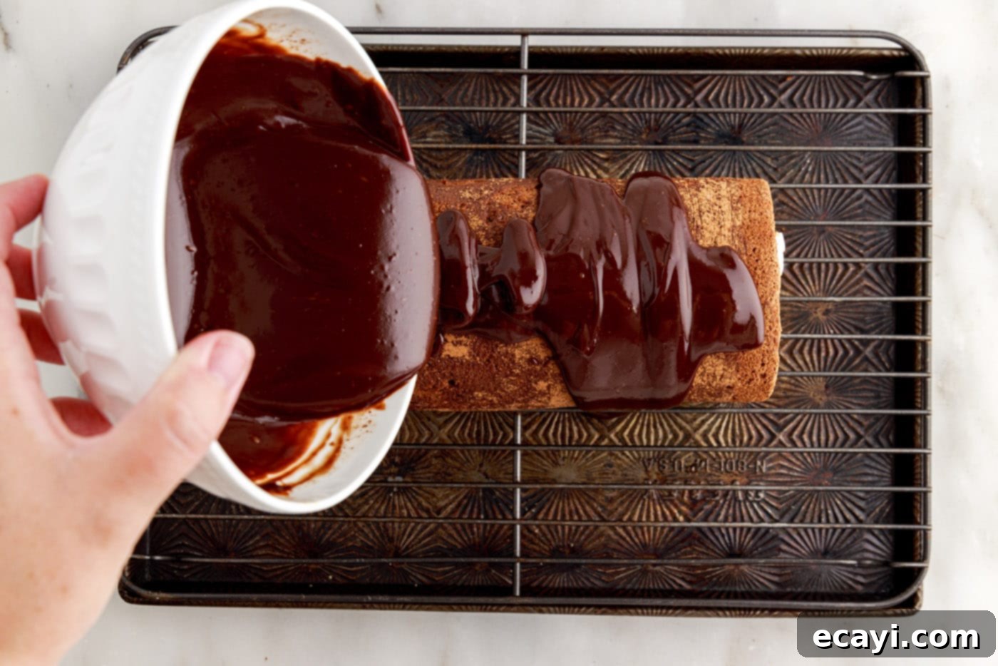 Velvet Chocolate Swirl 26 pouring chocolate ganache on top of swiss roll