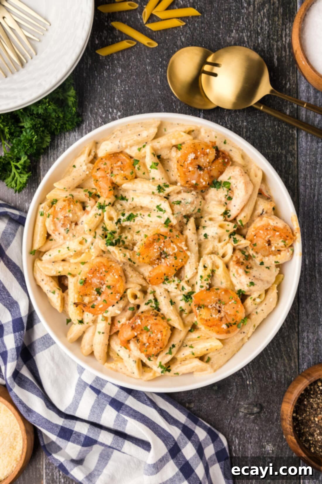 Creamy Cajun Shrimp Pasta 2 A beautifully presented bowl of creamy Cajun shrimp pasta, garnished with fresh parsley, with serving spoons elegantly placed beside it.