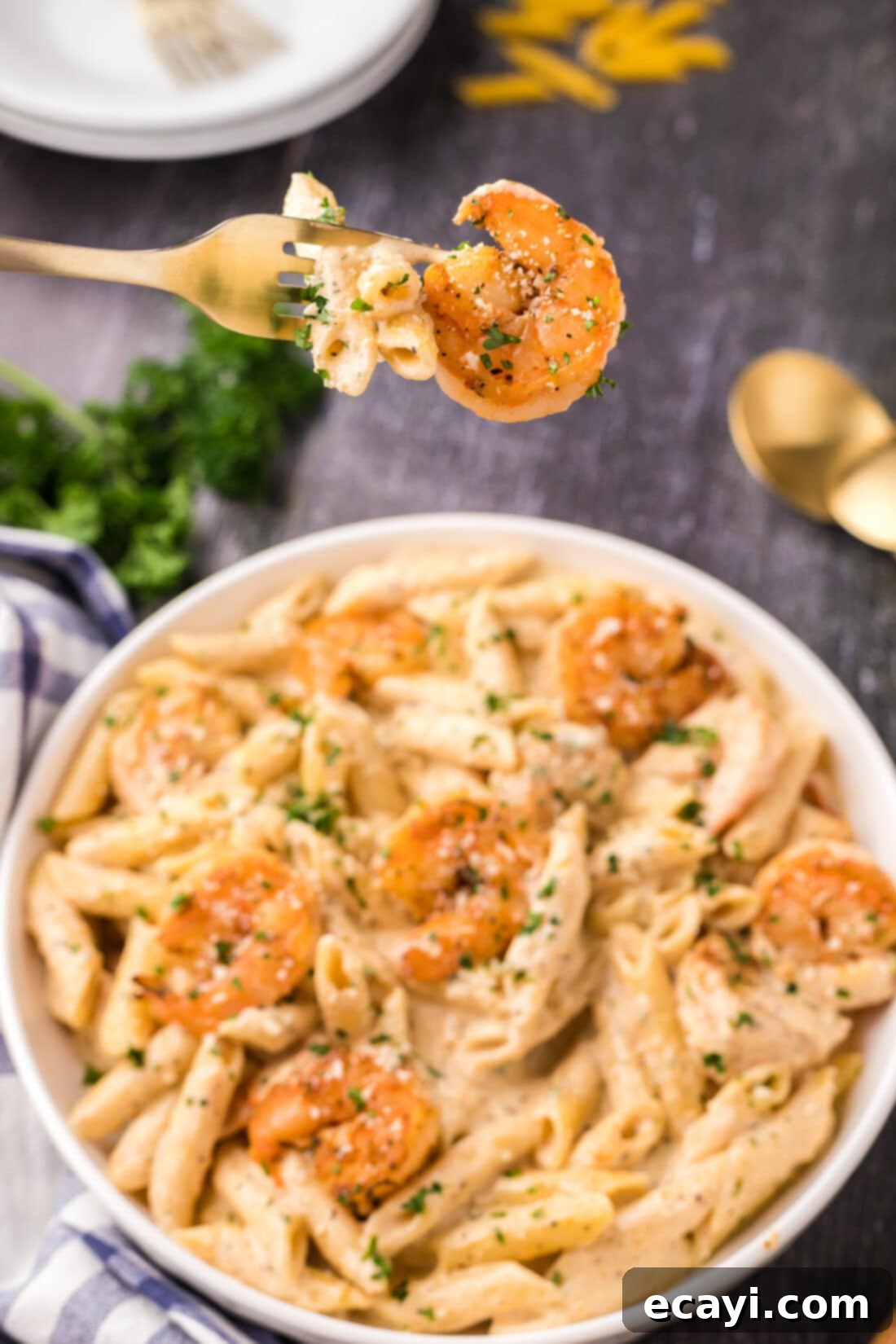 Creamy Cajun Shrimp Pasta 3 A close-up shot of creamy Cajun shrimp pasta being twirled on a fork, held above a rustic bowl, highlighting the rich sauce and plump shrimp.