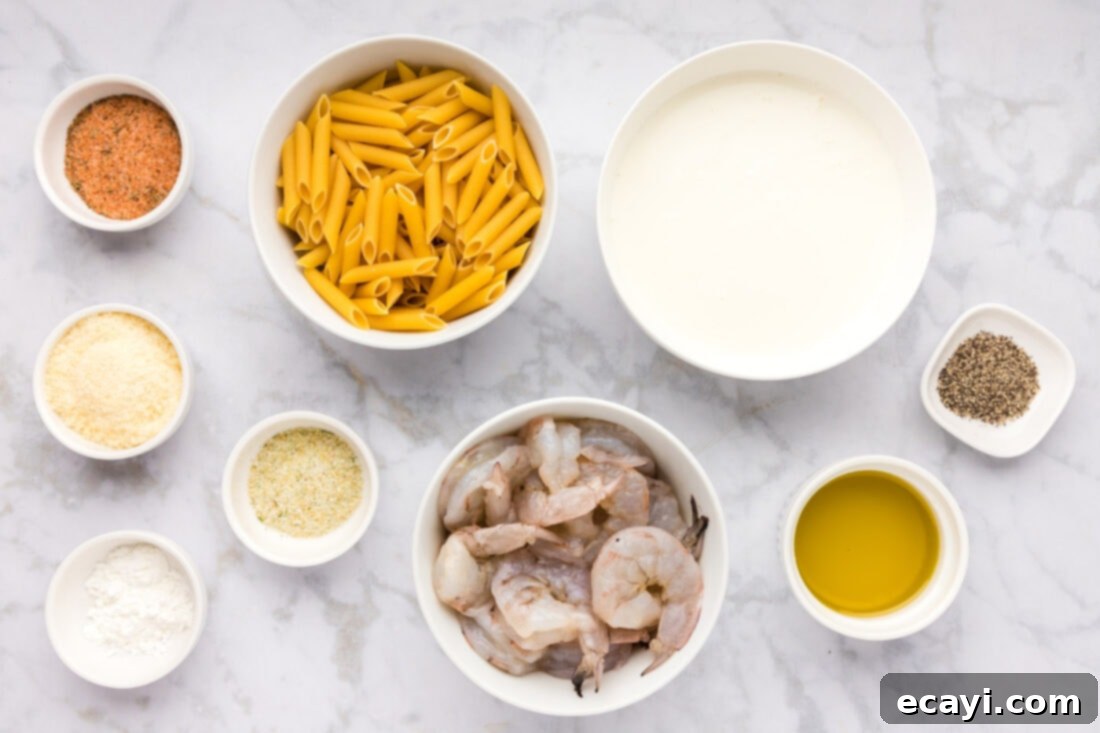 Creamy Cajun Shrimp Pasta 4 An overhead shot of all the fresh ingredients laid out for making Cajun shrimp pasta, including raw shrimp, pasta, fresh cream, and various seasonings.