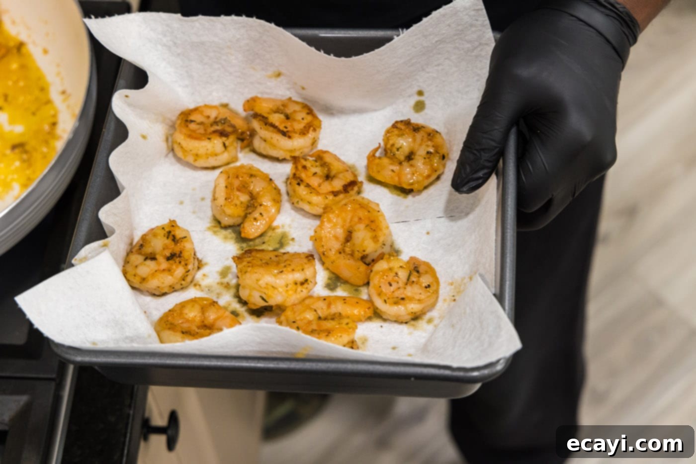 Creamy Cajun Shrimp Pasta 8 Cooked shrimp resting on a paper towel-lined baking sheet, waiting to be added back to the pasta.