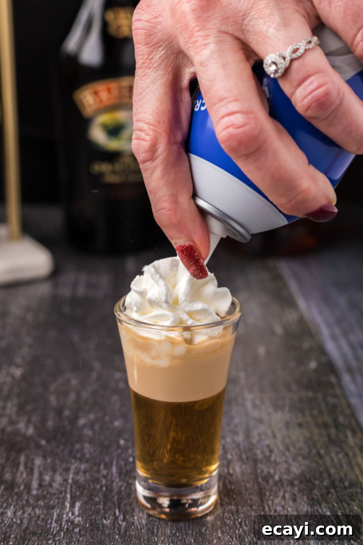 Buttery Nipple Bliss 9 Adding whipped cream on top of the finished Buttery Nipple Shot