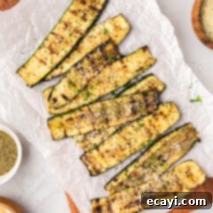 Smoky Zucchini Perfection 11 Grilled Zucchini on a wooden platter topped with parmesan cheese, ready to be served as a healthy side dish.
