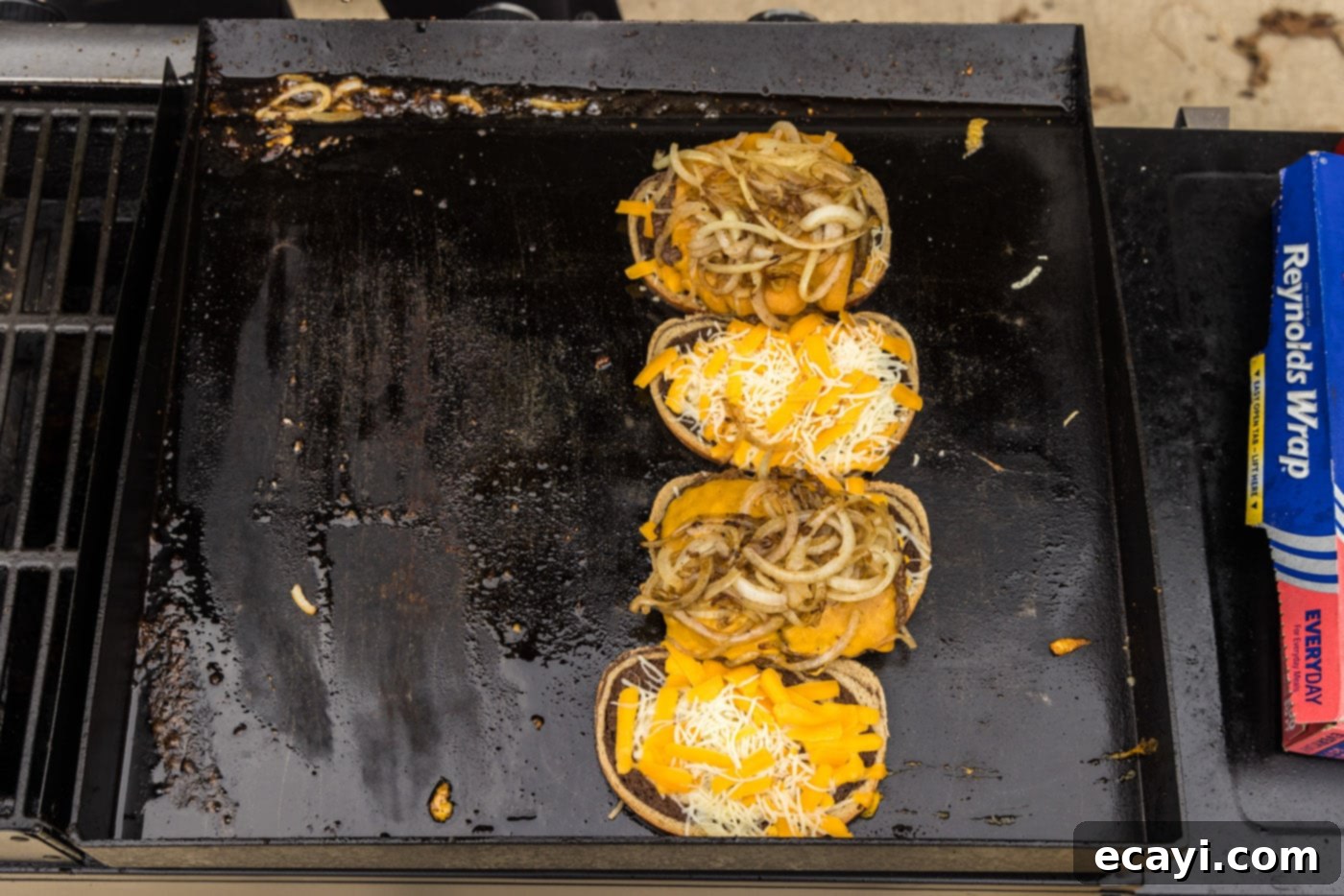 Patty Melt 17 onions on top of burger and rye bread on a grill