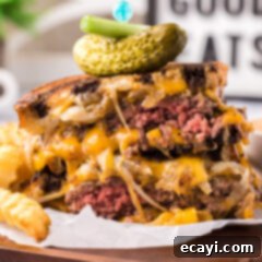 Patty Melt 21 Patty Melt cut in half stacked on top of each other topped with a pickle