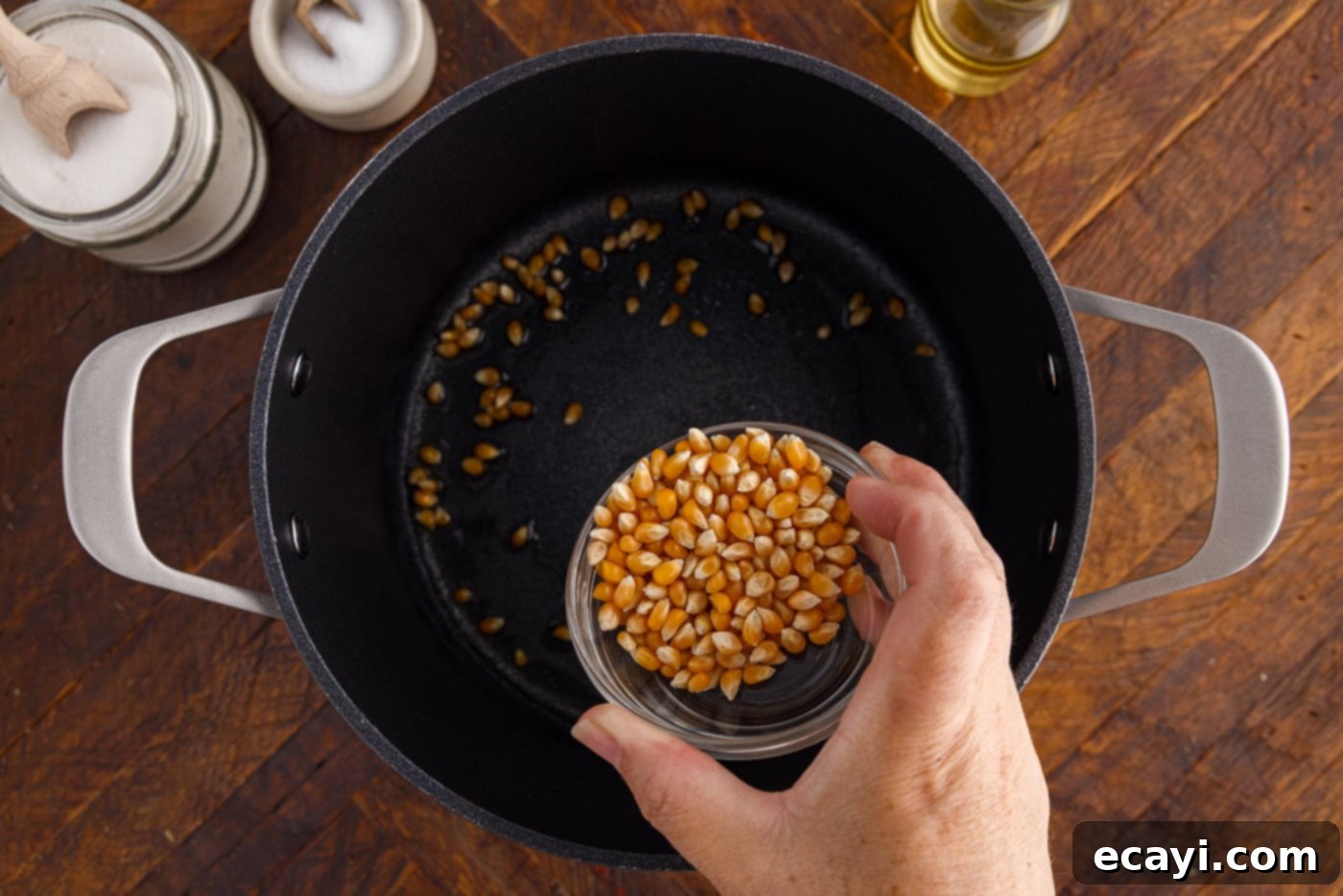 Irresistible Sweet & Salty Crunch 6 Corn kernels being added to hot oil in a pot