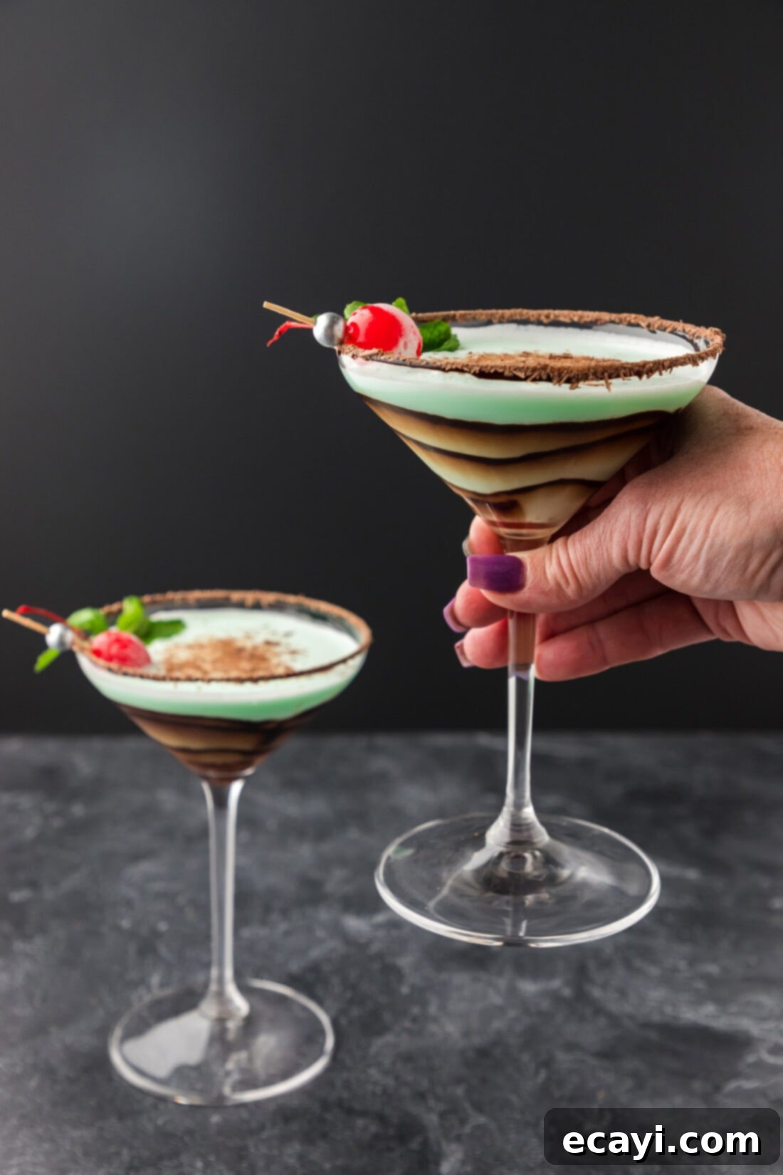 Velvet Grasshopper 3 Hand holding up a perfectly chilled Grasshopper Drink in a martini glass