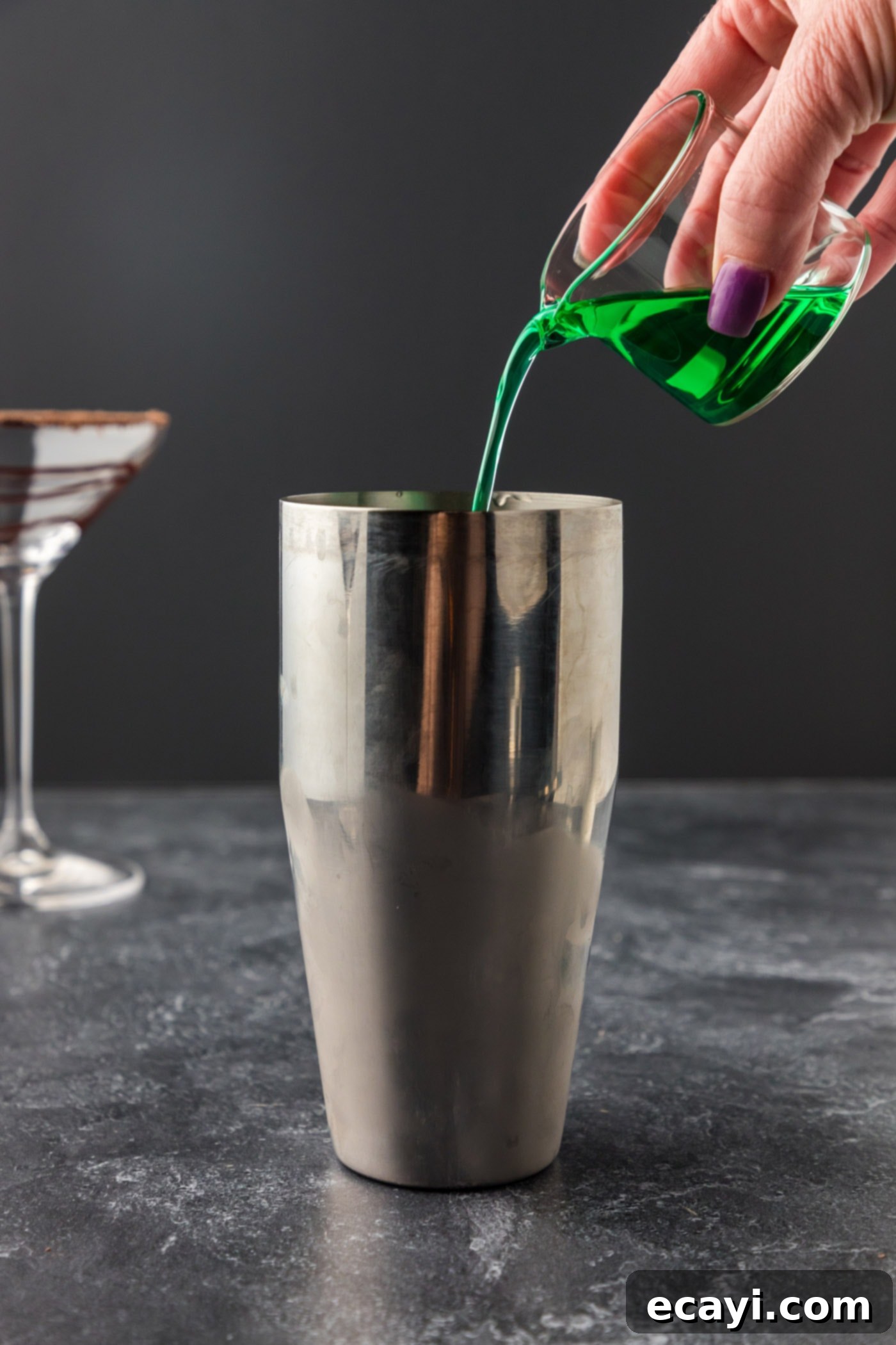 Velvet Grasshopper 9 pouring creme de menthe into cocktail shaker with other ingredients