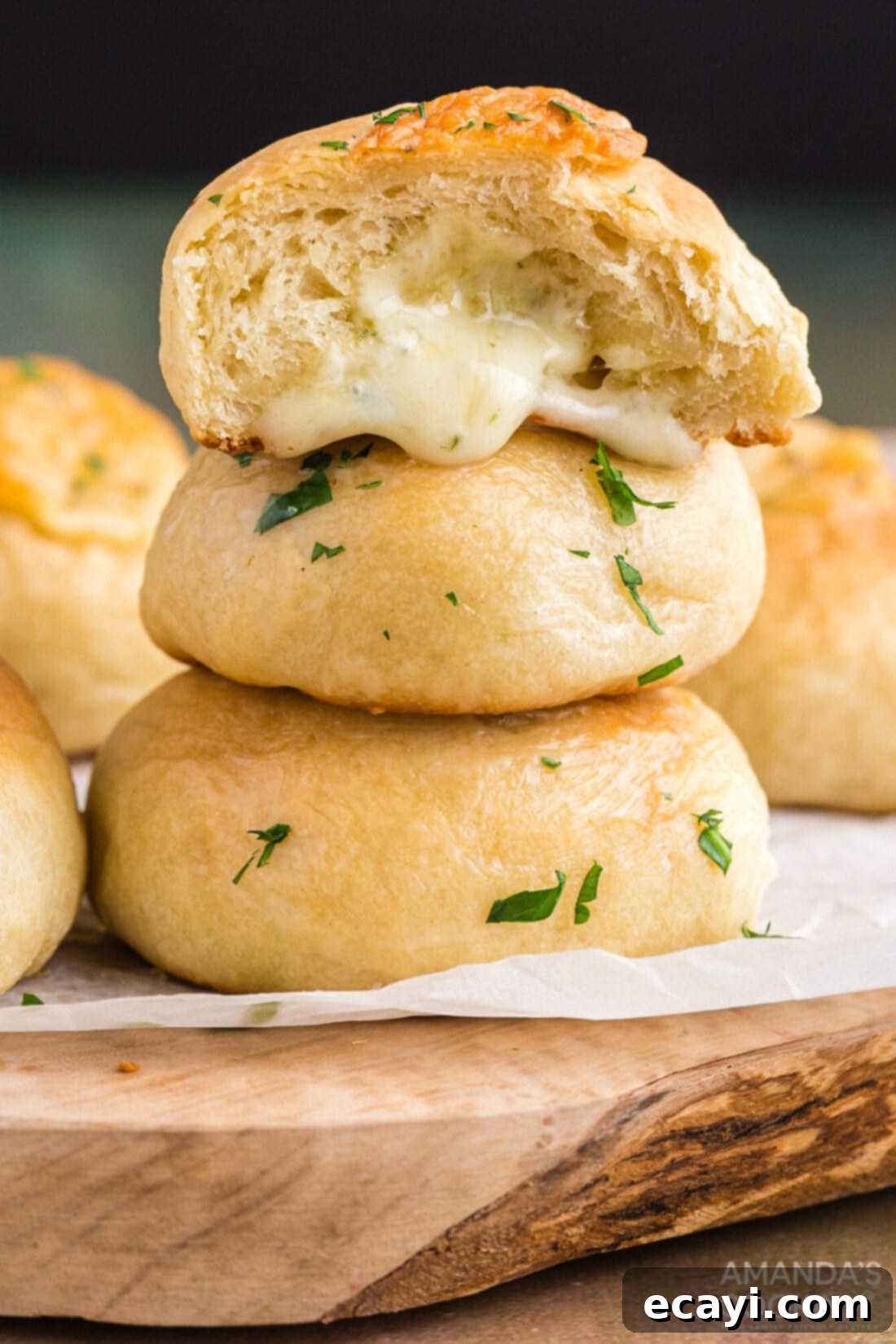 Golden Cheesy Garlic Buns 2 cheese rolls stacked on a cutting board