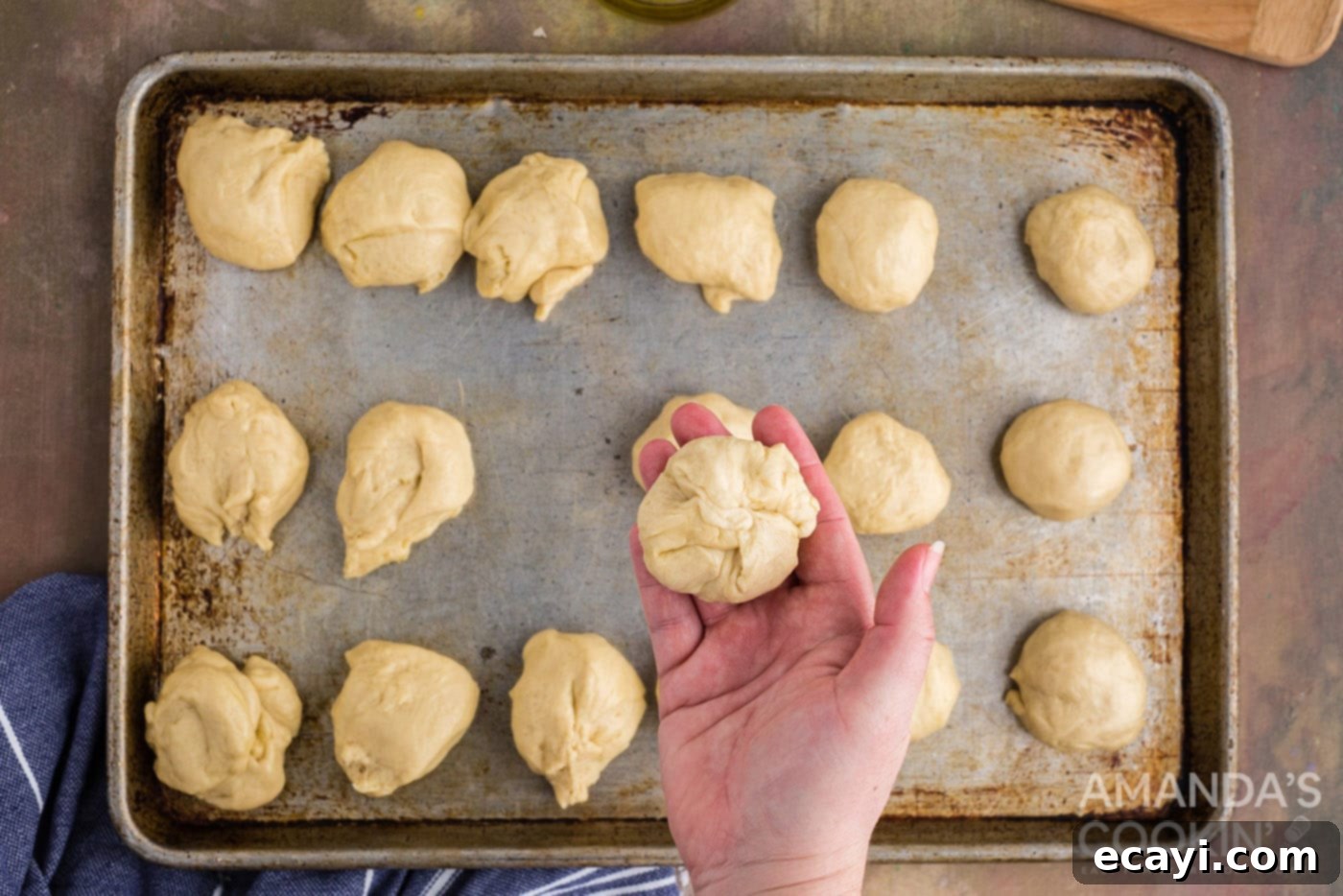 Golden Cheesy Garlic Buns 11 pinched dough ball in a hand