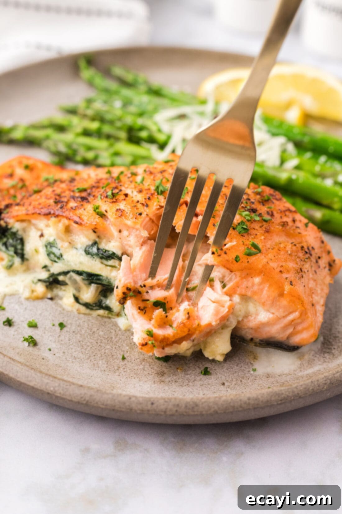 Gourmet Stuffed Salmon 21 Fork breaking a piece of Stuffed Salmon off the filet