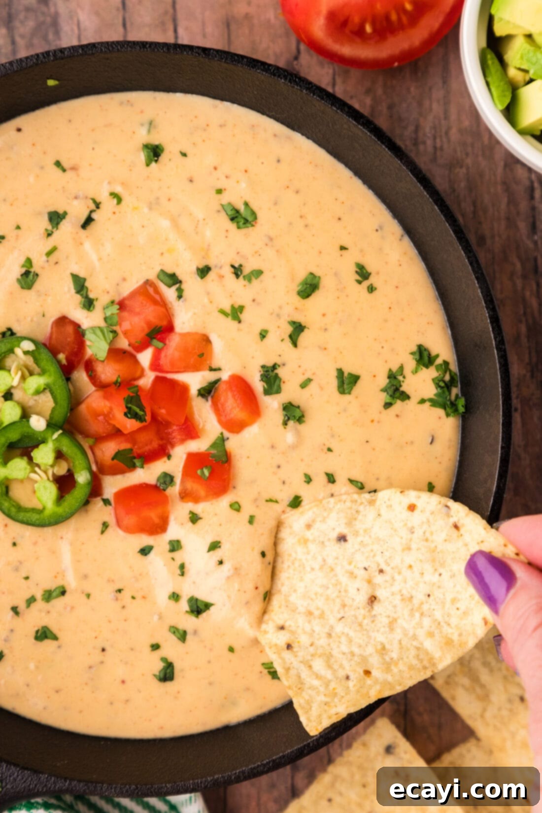 Creamy Queso 2 Tortilla chip being dipped into a skillet of creamy homemade White Queso Dip with peppers