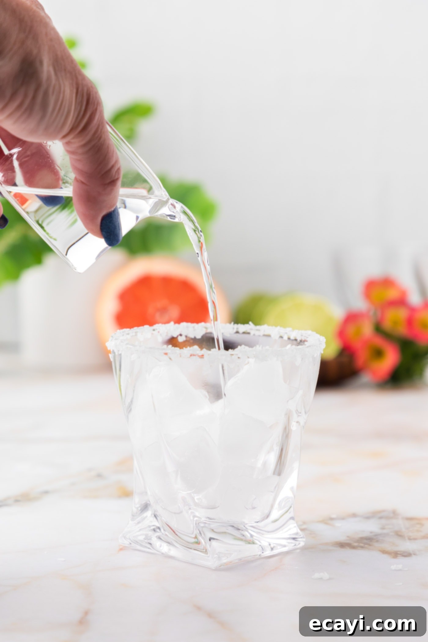 Paloma 8 pouring tequila into rock glass