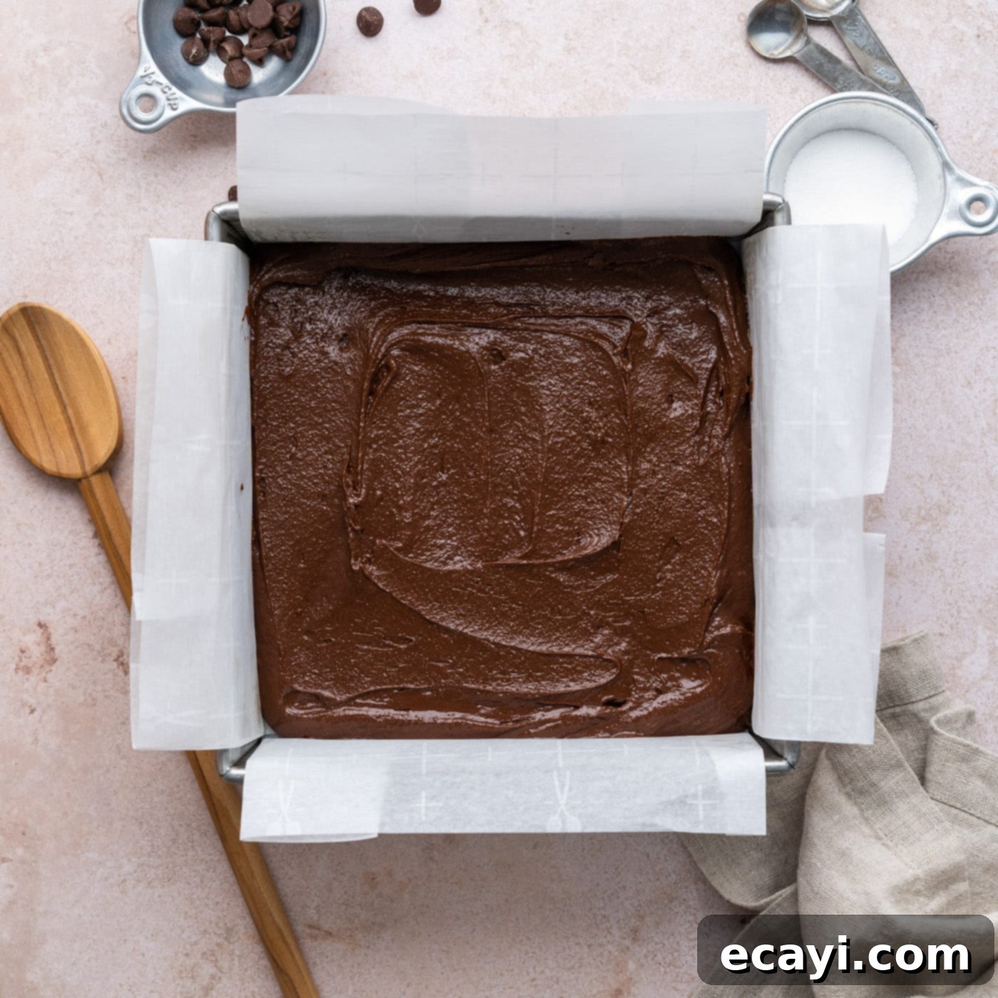 Decadent Millionaire Brownies 12 Brownie batter spread evenly in the parchment-lined baking pan.