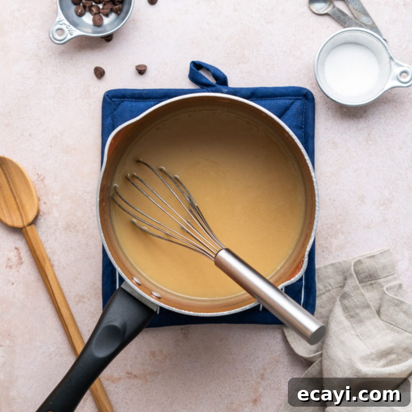 Decadent Millionaire Brownies 14 Whisking the homemade caramel mixture continuously in a saucepan over heat.