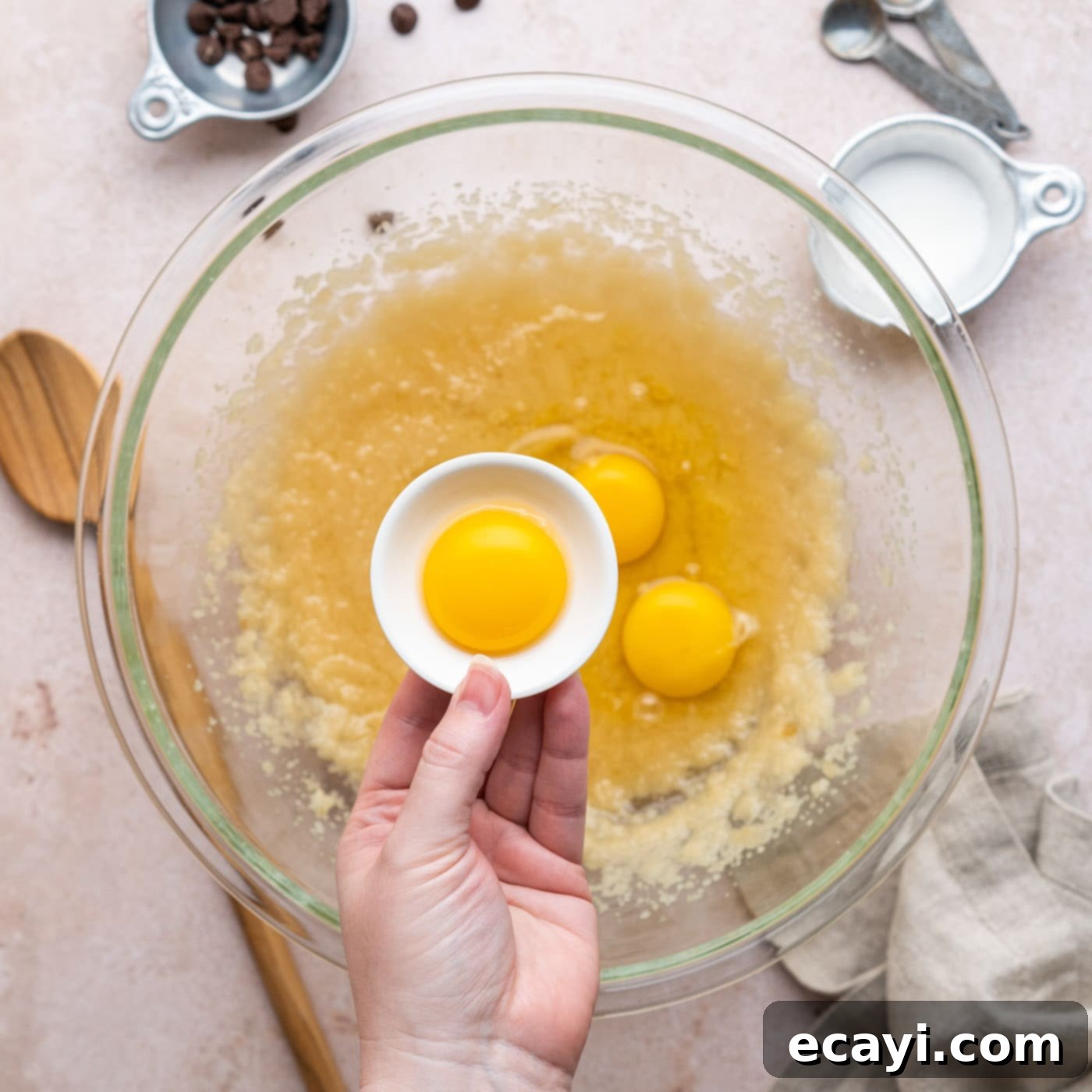 Decadent Millionaire Brownies 8 Adding an egg yolk to the brownie batter mixture in the bowl.