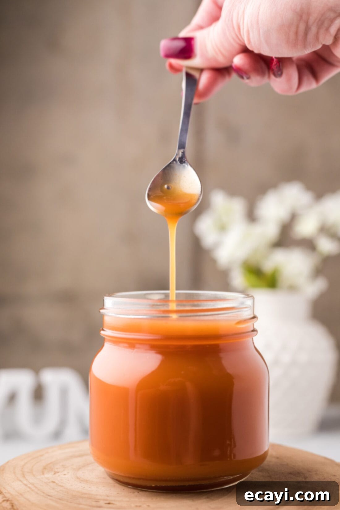 Zesty Sweet Fusion 9 Sweet and Sour Sauce being drizzled off a spoon into a jar