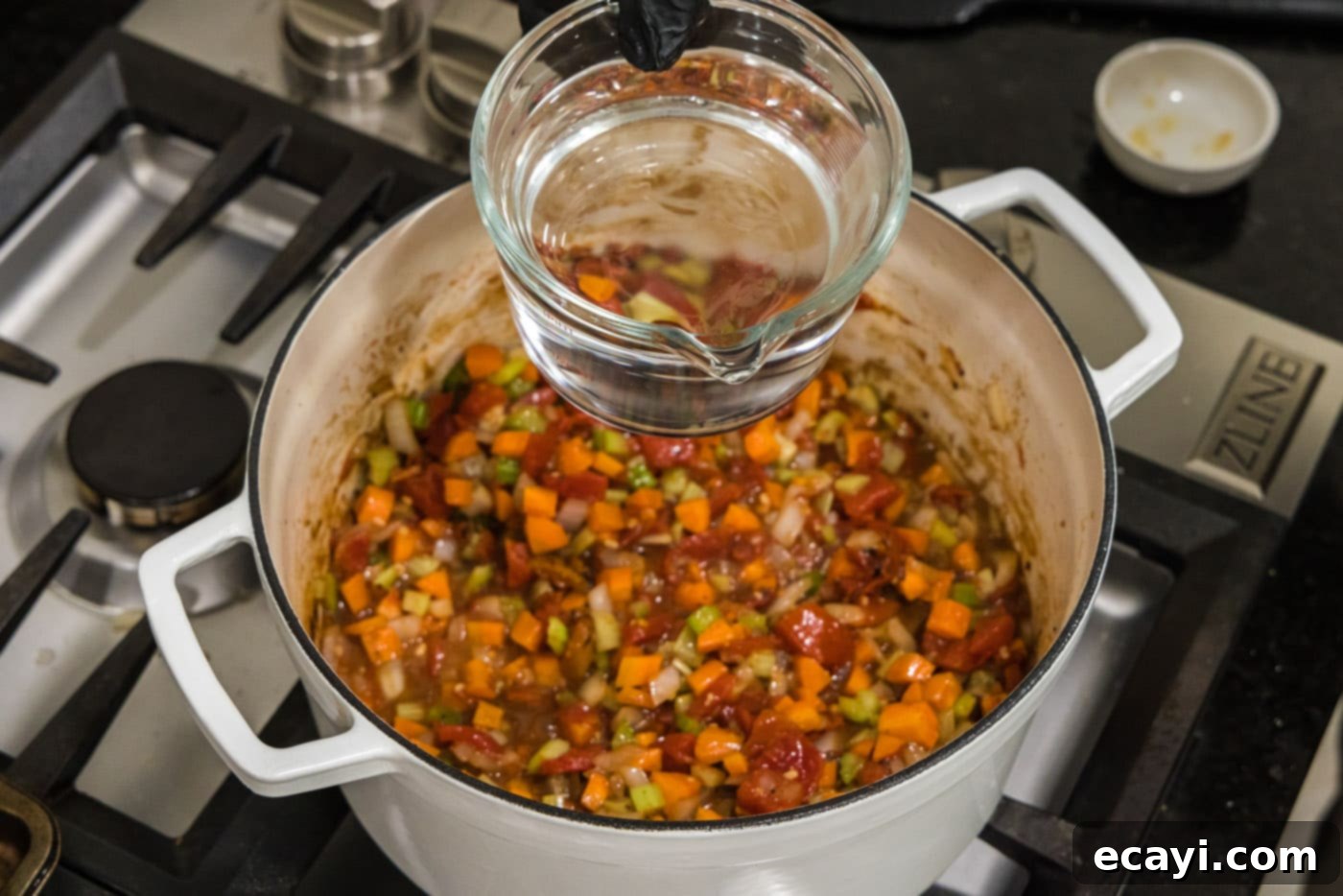 Melt-in-Your-Mouth Braised Beef Shanks 17 Pouring water into the Dutch oven with vegetables and braising liquid