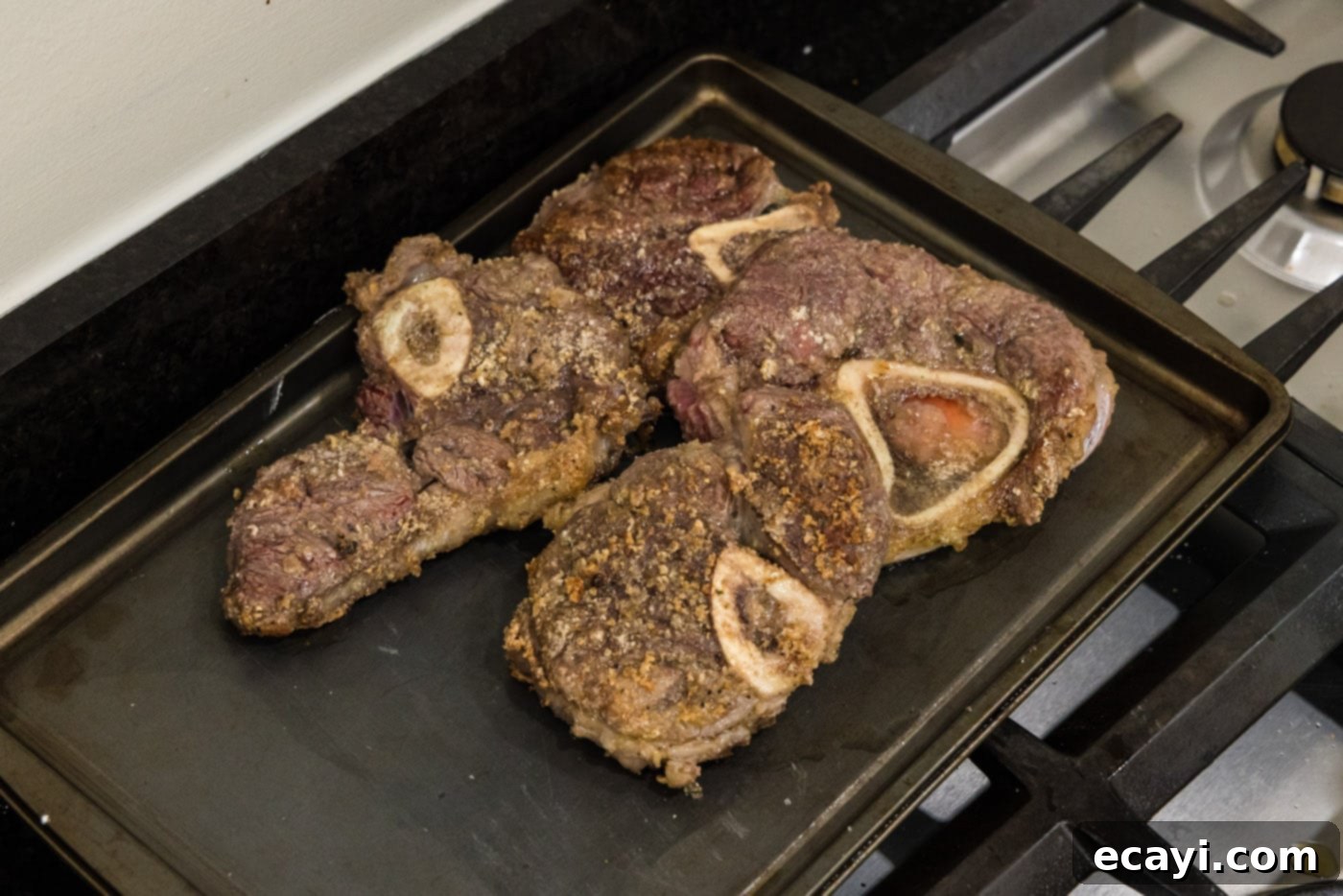 Melt-in-Your-Mouth Braised Beef Shanks 9 Perfectly seared beef shanks resting on a baking pan after browning