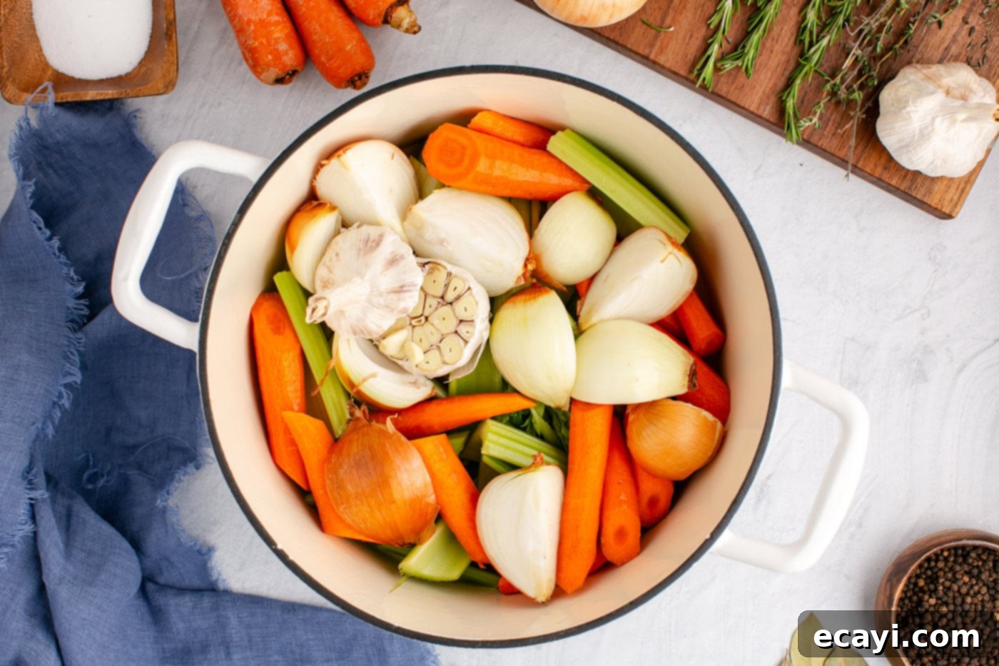Garden Elixir 5 Roughly chopped carrots, celery, onion halves, and garlic bulbs placed at the bottom of a large stockpot