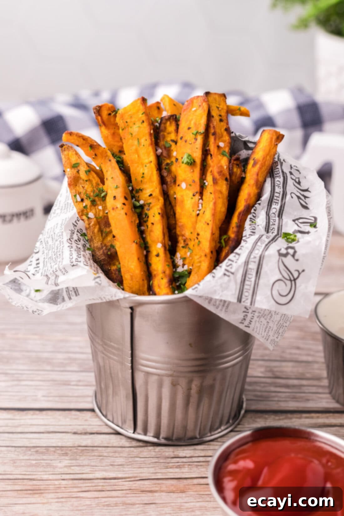 Perfectly Crispy Air Fryer Sweet Potato Fries 13 Air Fryer Sweet Potato Fries served in a metal fry cup with parchment paper