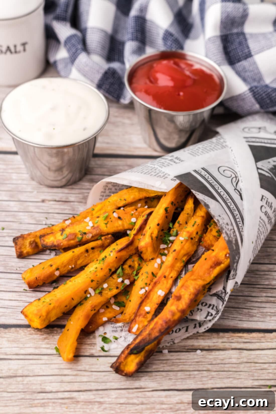 Perfectly Crispy Air Fryer Sweet Potato Fries 3 Air Fryer Sweet Potato Fries wrapped in parchment paper, ready to be served