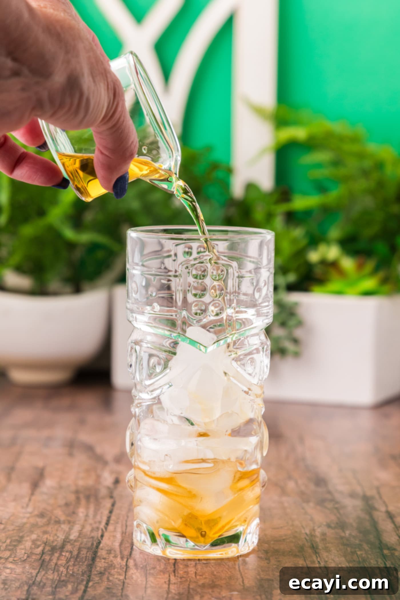 The Kingston Mule 6 pouring rum into glass with ice