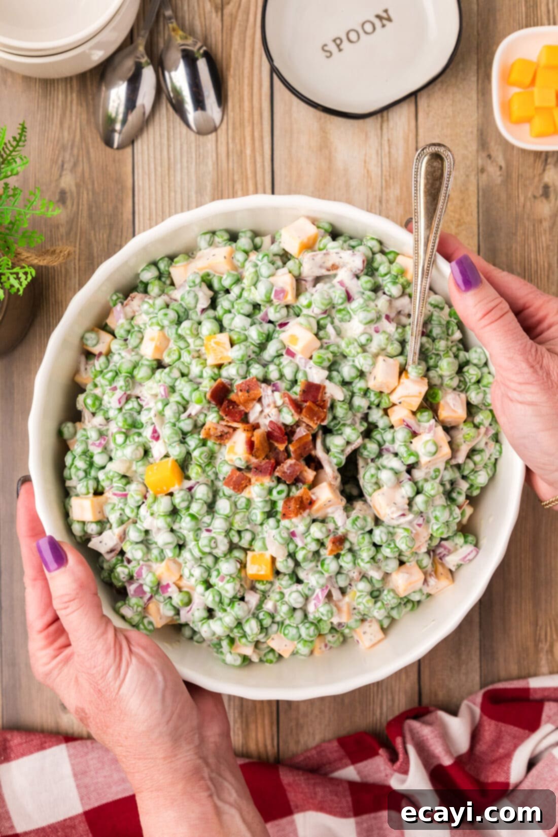 Refreshing Creamy Pea Salad 3 Hands holding a bowl of freshly made Classic Pea Salad.