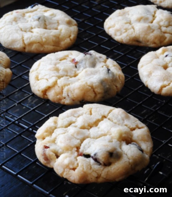 Ruby Red White Chocolate Delights 7 A close up photo of cherry white chocolate chip cookies on a cooling rack.