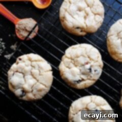 Ruby Red White Chocolate Delights 8 An overhead photo of cherry white chocolate chip cookies on a cooling rack.