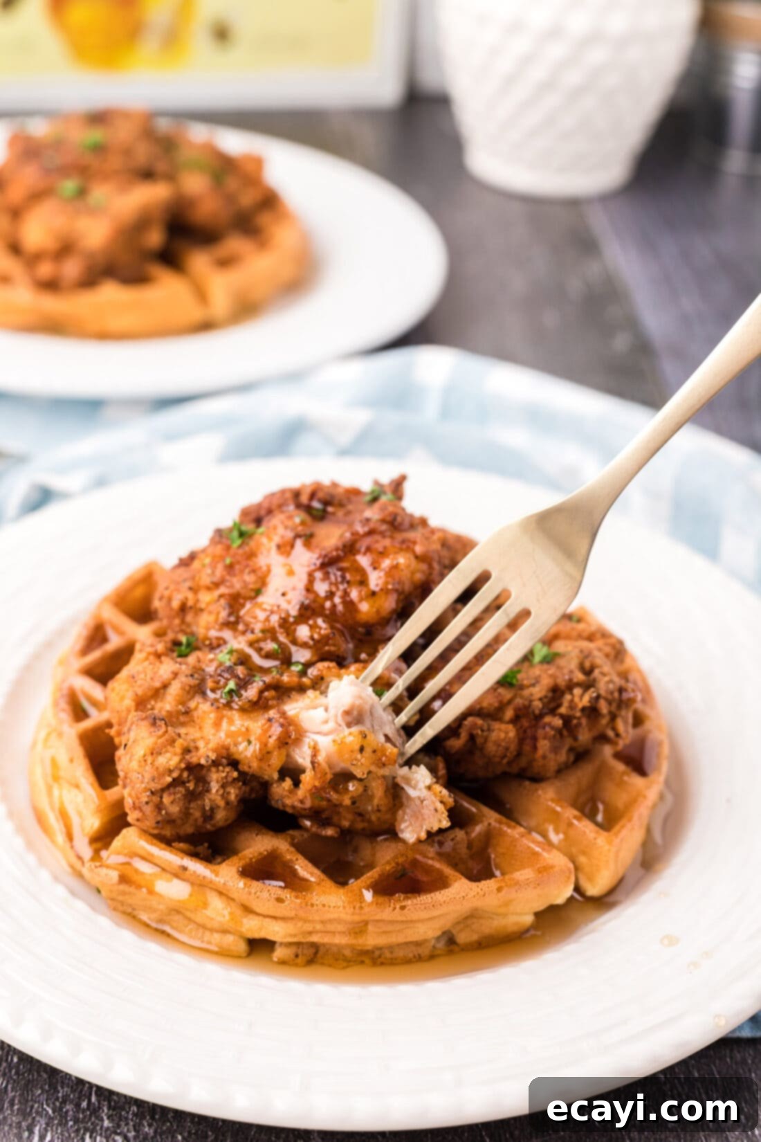 Southern Comfort Bliss 17 A fork taking a delicious piece of Chicken and Waffles, showing the crispiness of the chicken and softness of the waffle