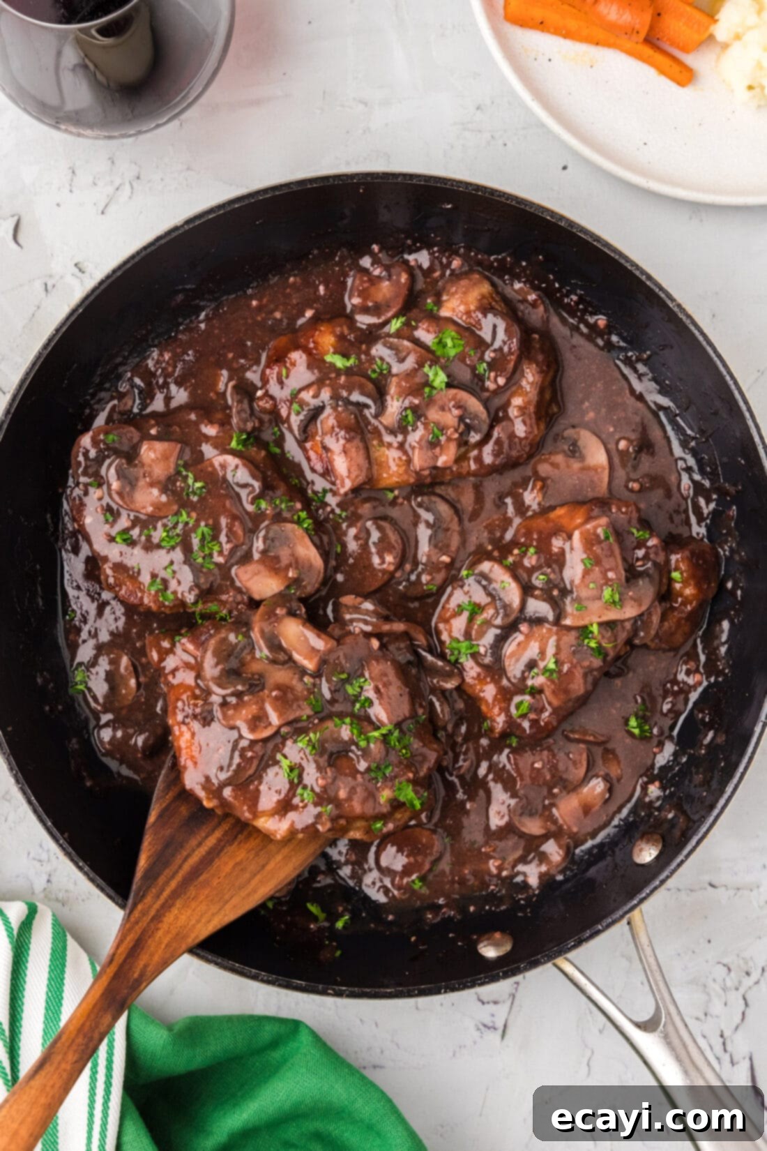 Classic Veal Marsala 2 Sizzling Veal Marsala in a skillet, ready to serve, with a wooden spatula resting nearby.