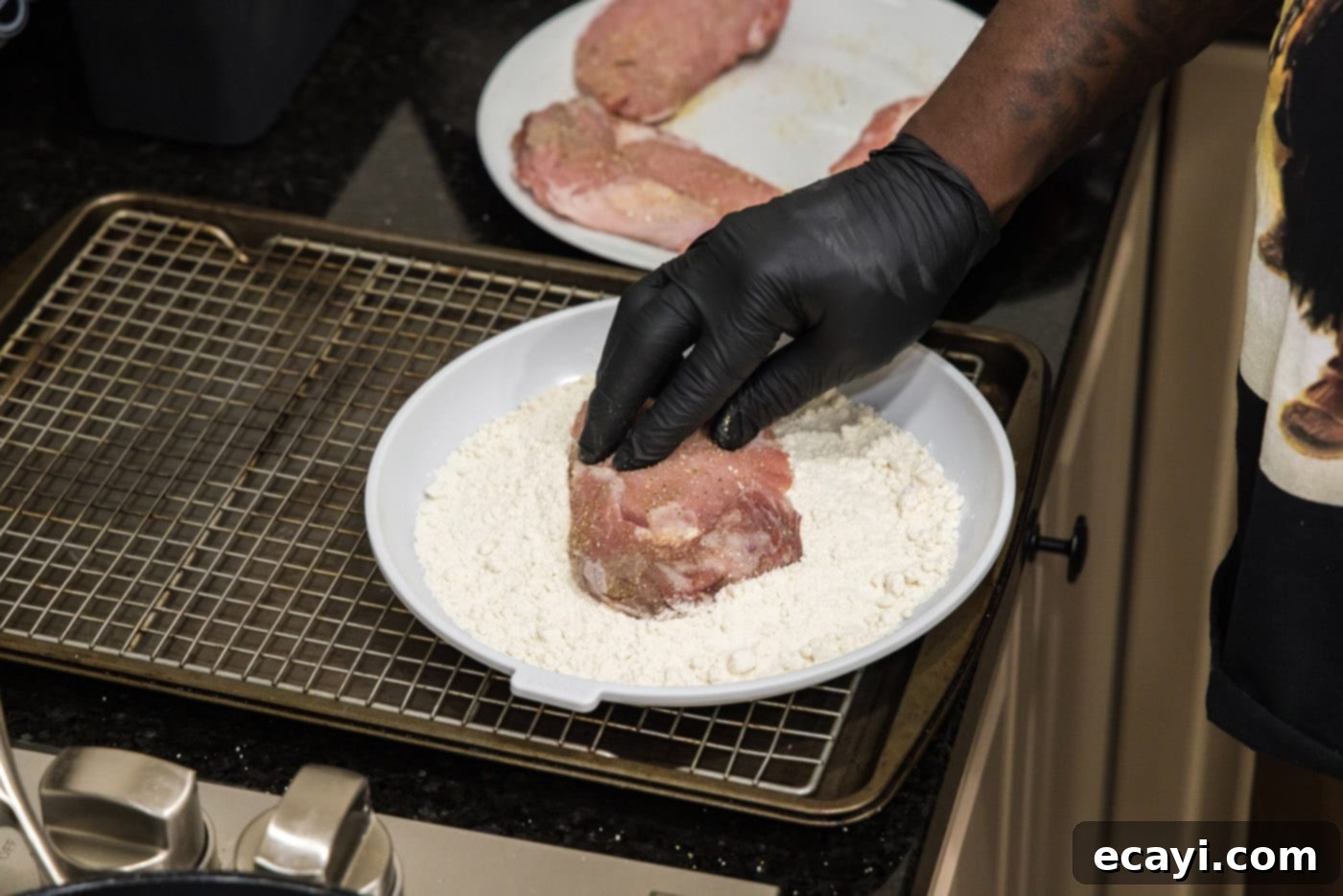 Classic Veal Marsala 5 Pressing a veal chop into flour to coat it evenly for frying.
