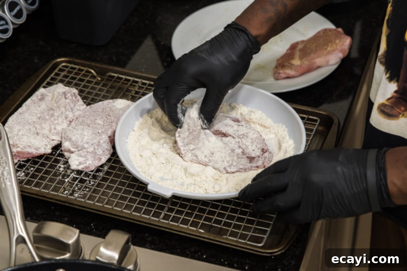 Classic Veal Marsala 6 A close-up shot of veal cutlets being dredged in flour, ensuring full coverage.