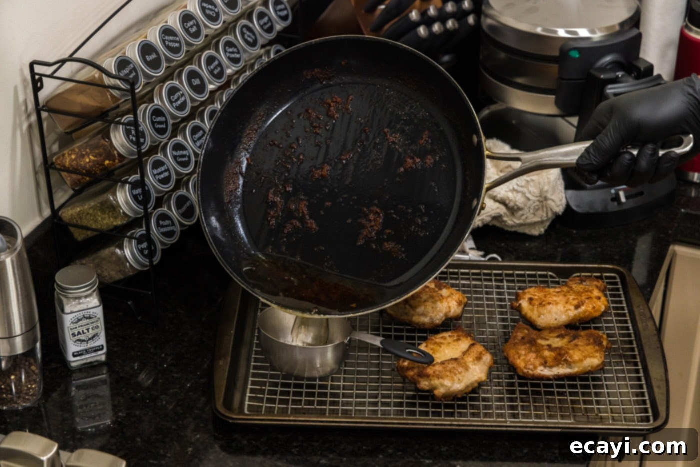 Classic Veal Marsala 9 Pouring pan drippings from the skillet into a measuring cup, leaving fond behind.