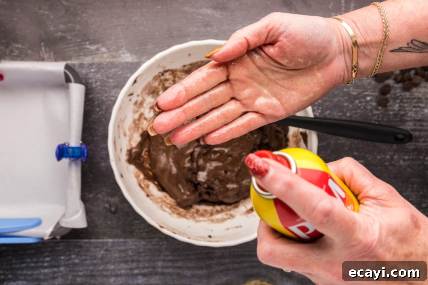 Foolproof Cake Mix Brownies 11 spraying hands with cooking spray to prevent sticking while pressing brownie batter