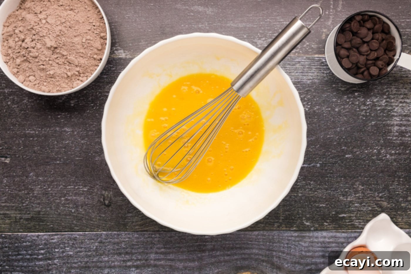 Foolproof Cake Mix Brownies 6 eggs, oil, and vanilla whisked together in a bowl, creating a smooth liquid mixture