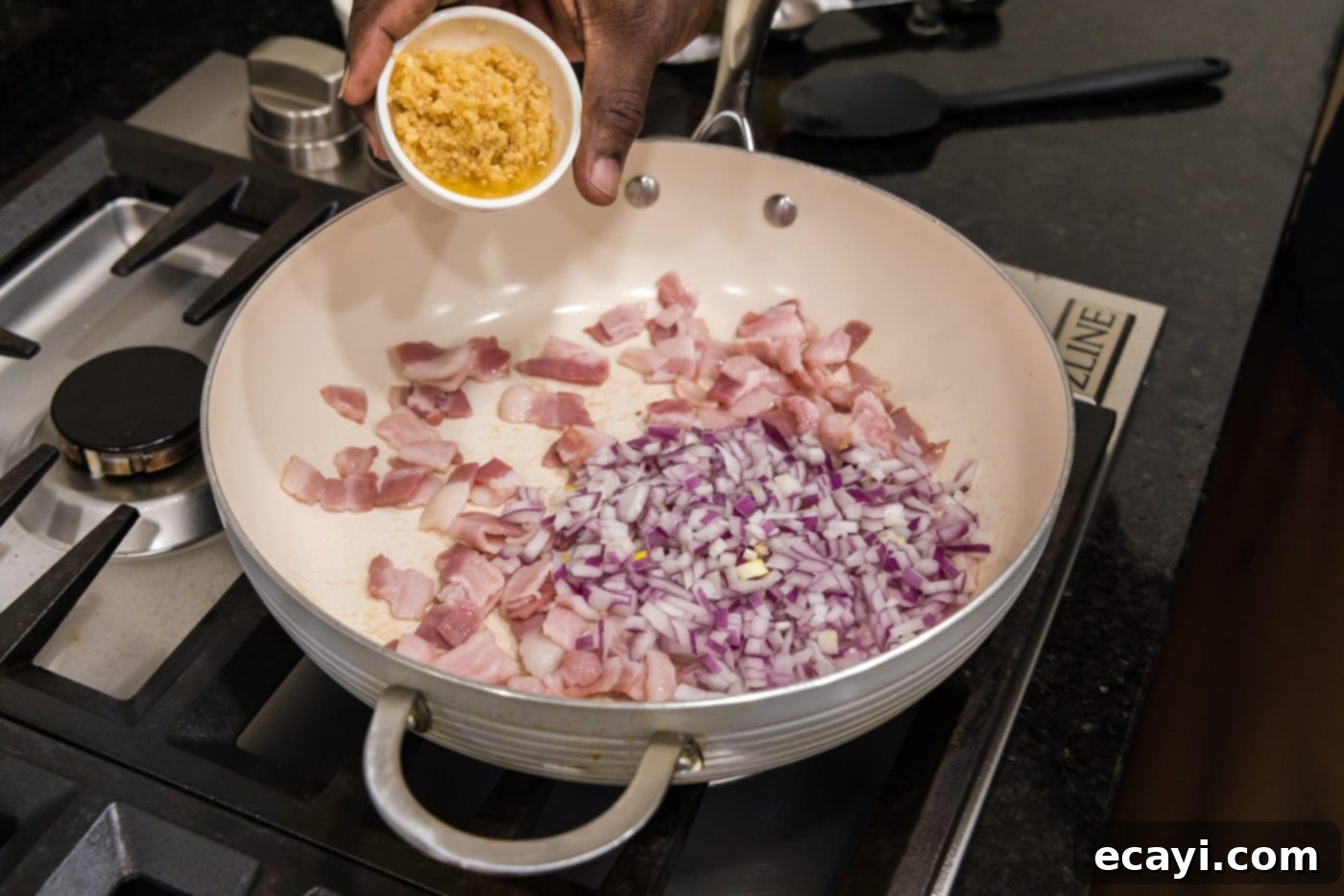 Homestyle Southern Green Beans 5 Adding minced garlic to a skillet with sizzling bacon and shallots