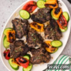 Succulent Grilled Lamb Loin 14 Grilled Lamb Loin Chops on a platter with roasted peppers and sliced cucumbers
