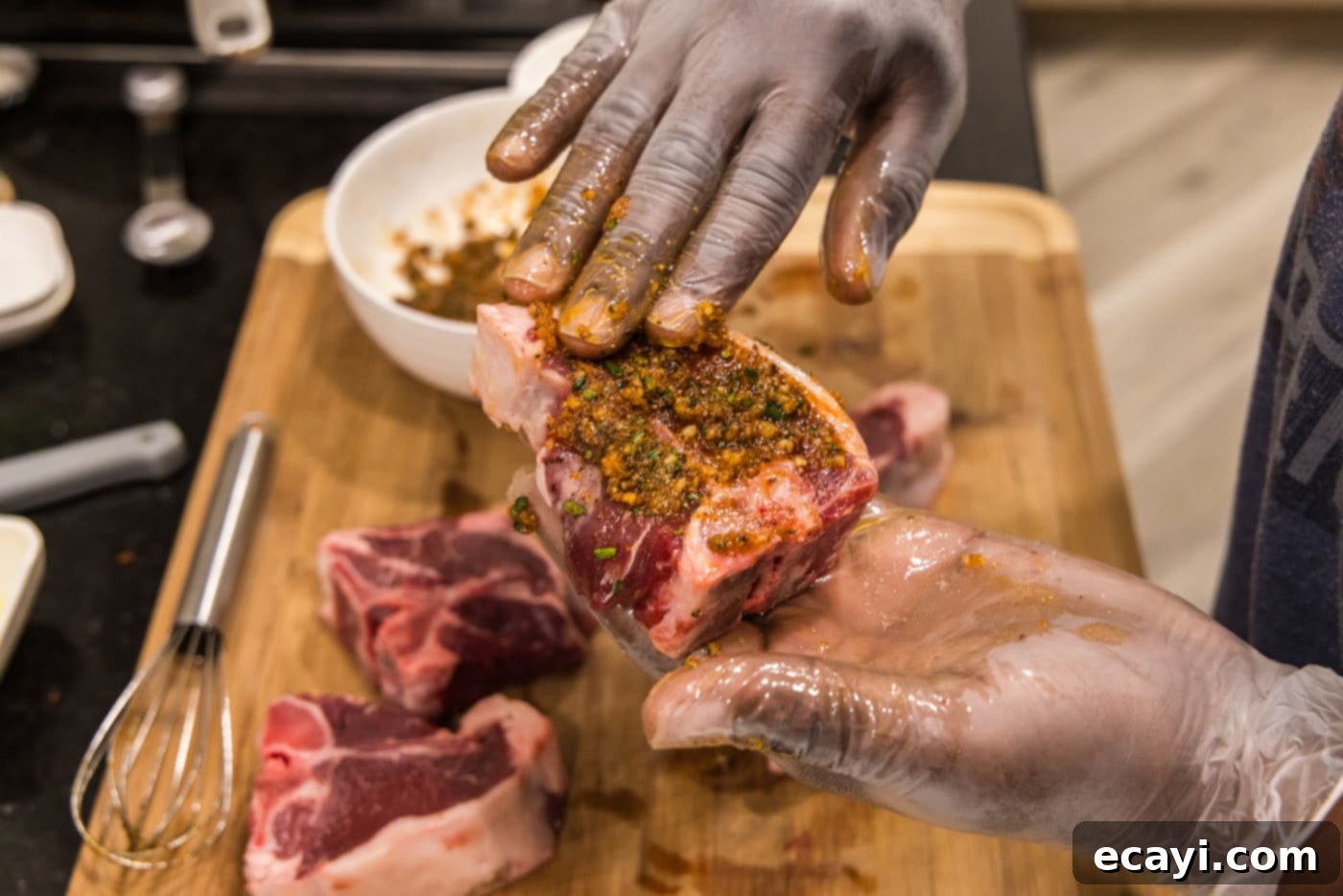 Succulent Grilled Lamb Loin 7 A gloved hand meticulously rubbing wet seasoning over lamb loin chops