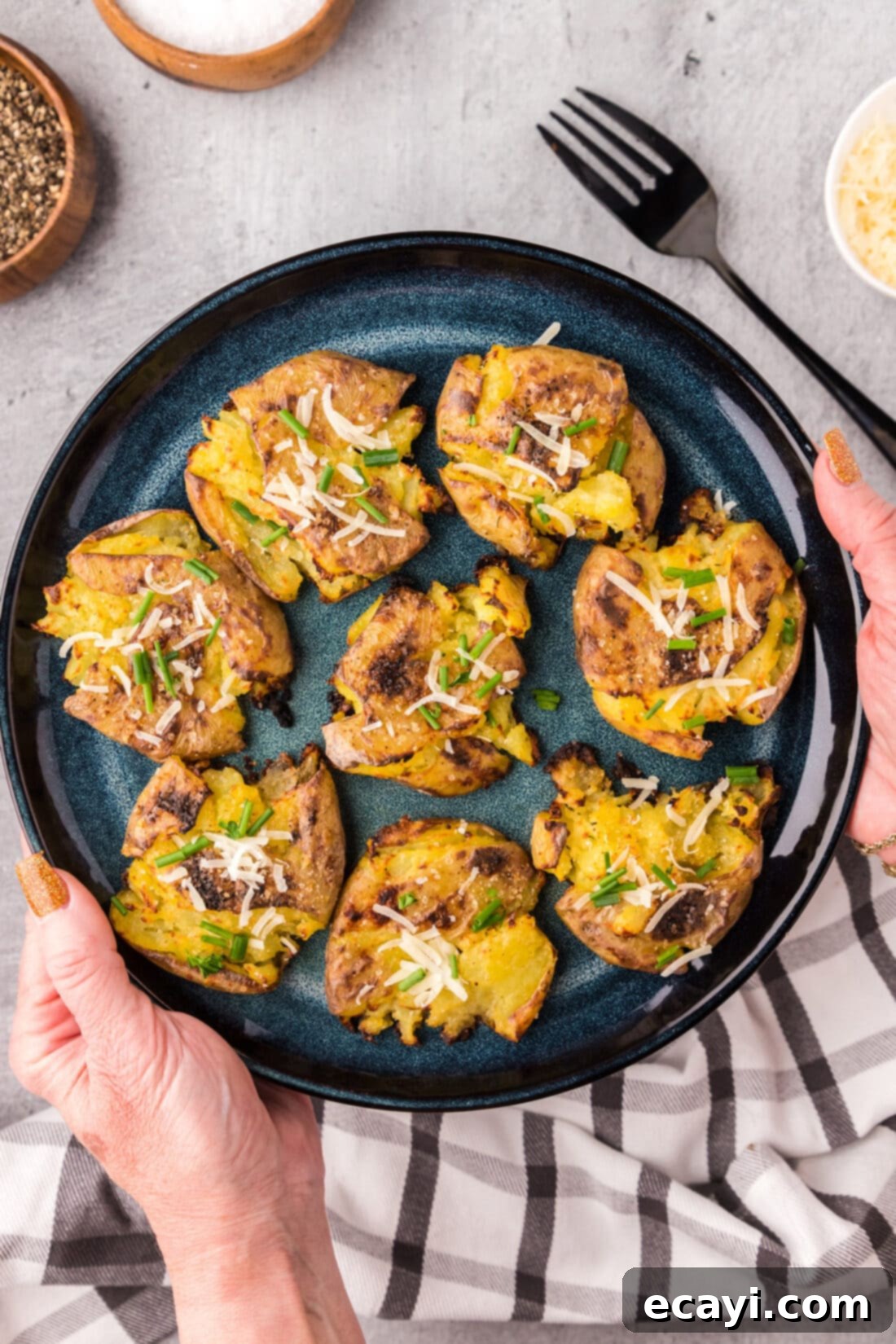 Crispy Smashed Spuds 12 Hands holding up a plate of perfectly crispy Smashed Potatoes, ready to eat