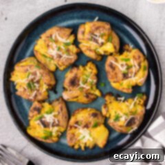 Crispy Smashed Spuds 13 Smashed Potatoes on a plate, garnished with fresh herbs