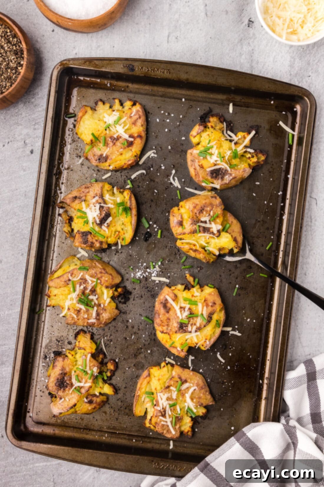 Crispy Smashed Spuds 3 Smashed Potatoes on a sheet pan with a serving fork, ready for the oven