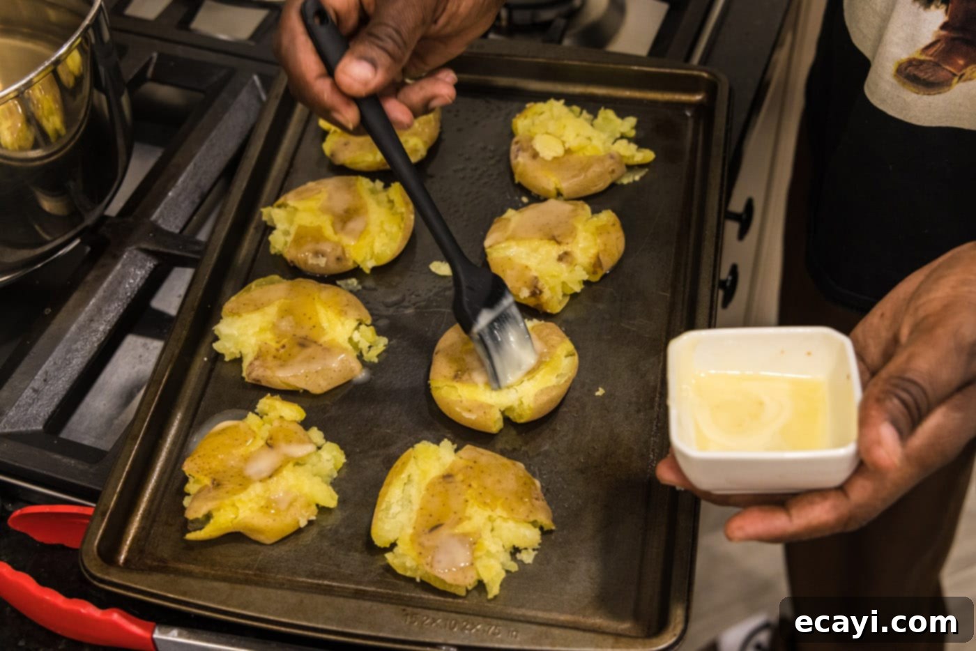 Crispy Smashed Spuds 9 rubbing smashed potatoes with melted butter on a baking sheet before seasoning