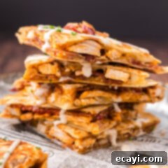 Ultimate Chicken Bacon Ranch Quesadillas 6 Close up photo of a stack of Chicken Bacon Ranch Quesadilla triangles, perfectly cut and showing off the cheesy filling.