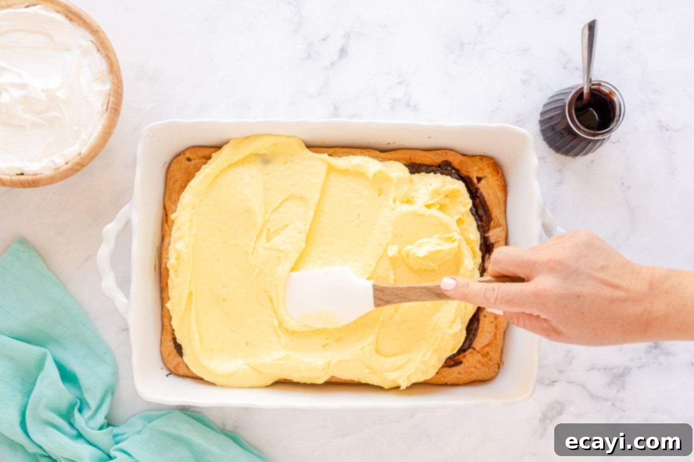 Ultimate Chocolate Eclair Puff Cake 8 spreading pudding mixture on top of chocolate and puffy pastry